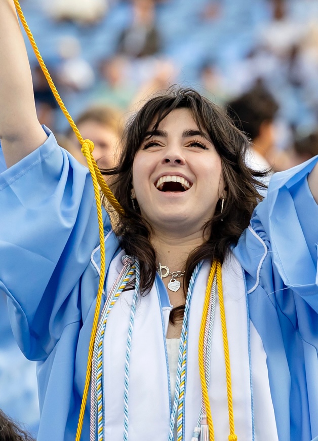 UNC graduation ceremony — a student in cap and gown celebrates.